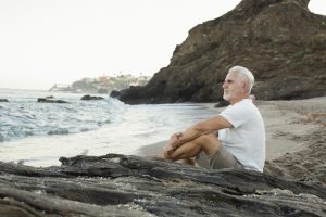 senior-man-resting-at-the-beach-and-admiring-the-ocean